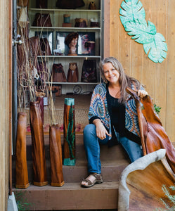 Shelley Hoist outside her studio with artwork around her